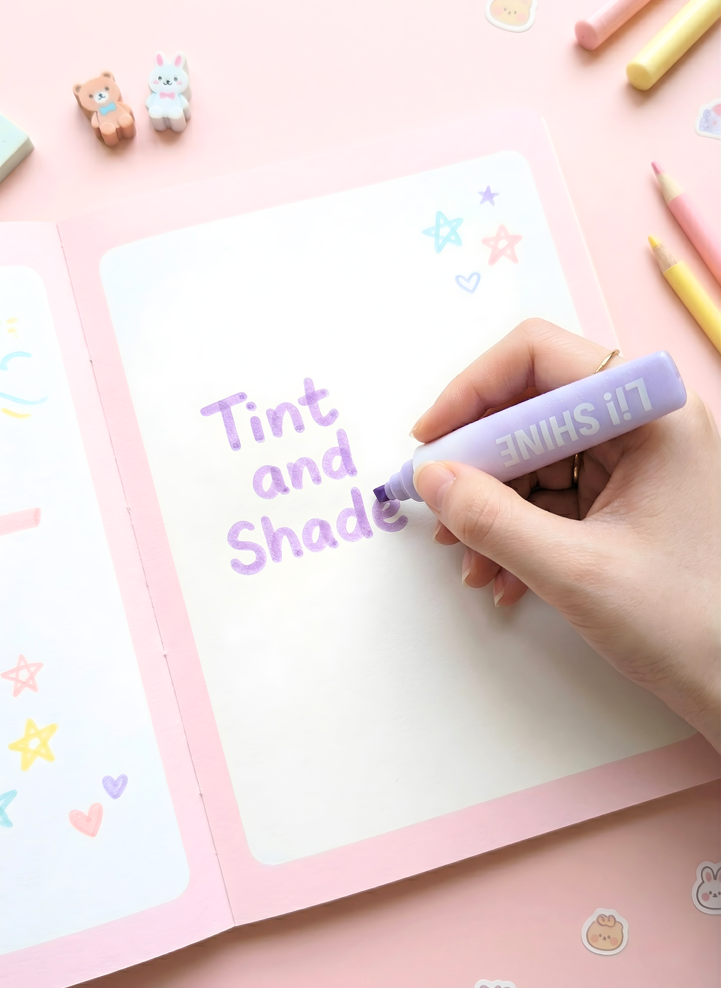 Hand holding a marker over a piece of paper with 'Tint and Shade' text, on a pink background with stationery items.