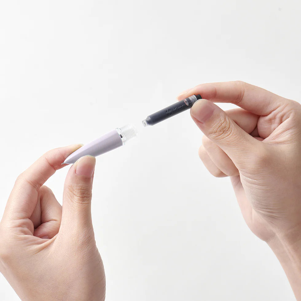 Two hands holding a pen with a white body and black cap against a light gray background