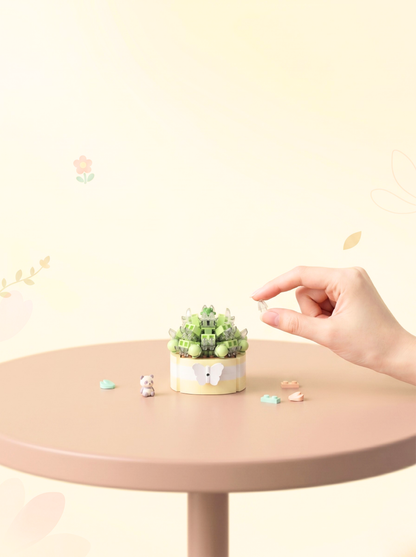 Small potted plant on a round table with a hand reaching towards it against a light background