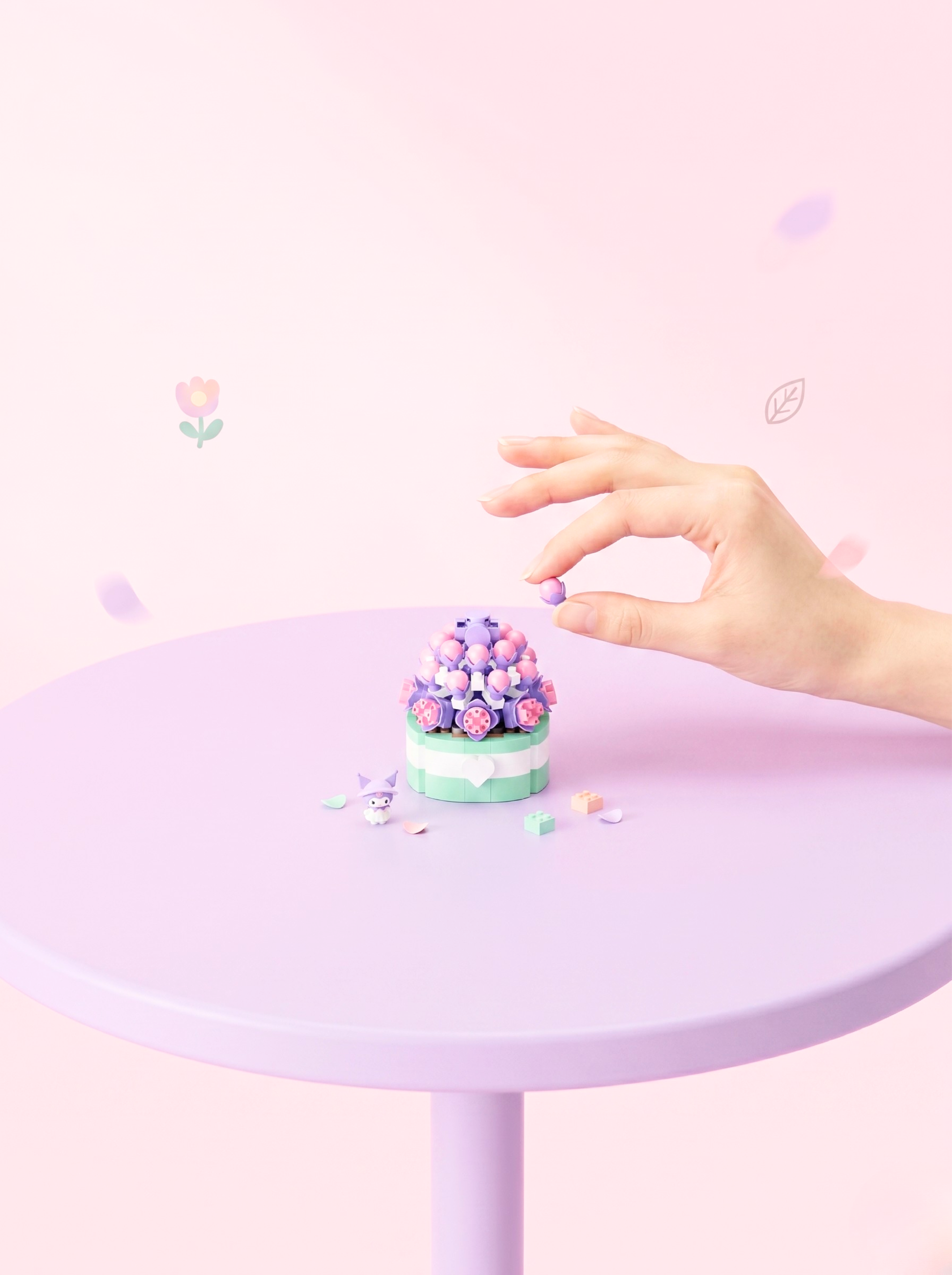 Pastel-colored cupcake on a small round table with a hand reaching towards it against a light pink background.