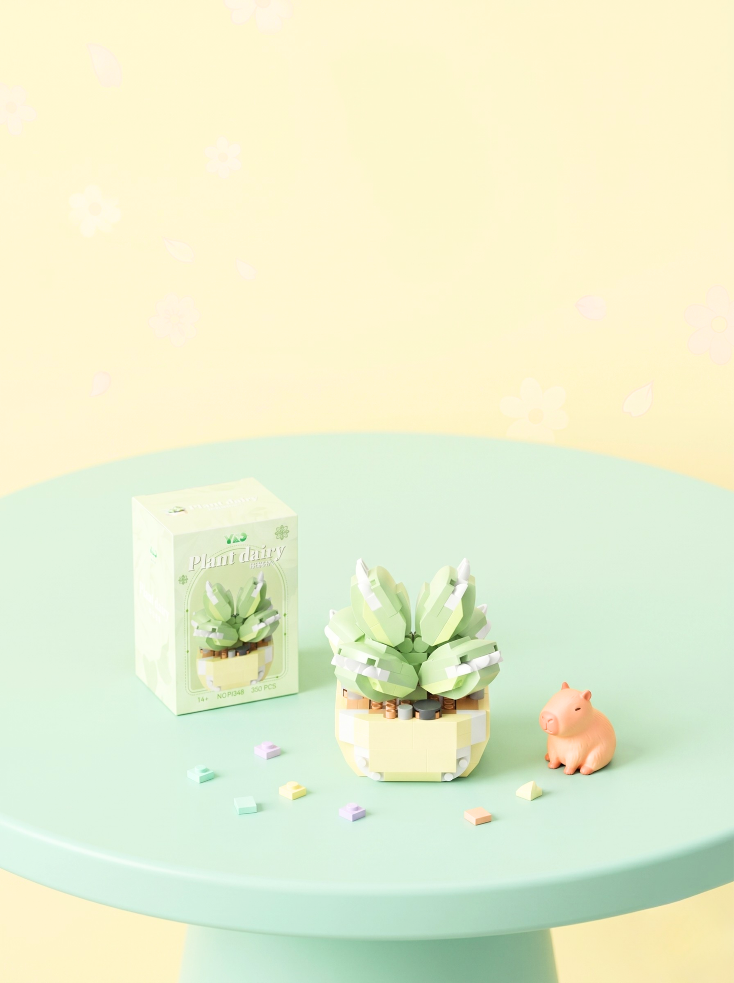 Small succulent plant in a decorative pot on a green pedestal with a box labeled 'Plants' and a small pink piggy bank.