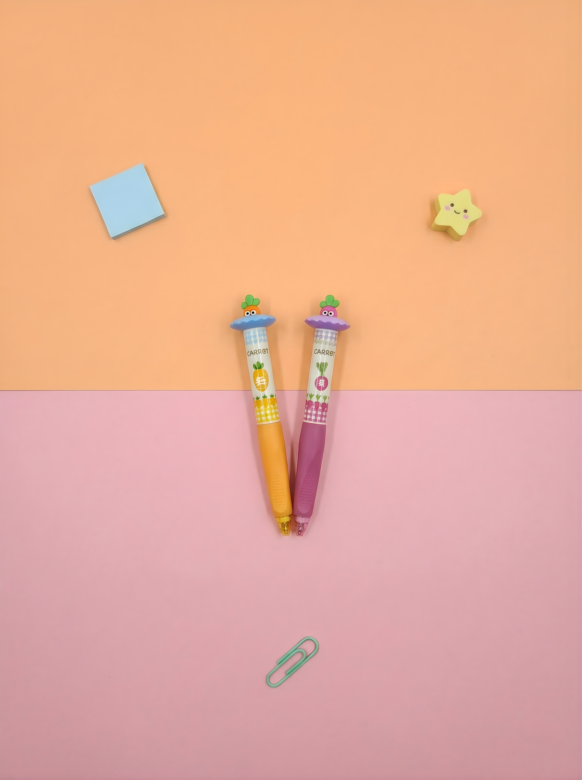 Two colorful pens with cartoon characters on a two-tone pink and orange background.
