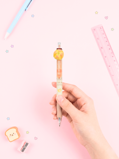 Hand holding a small mechanical pencil with a cute design on a pink background