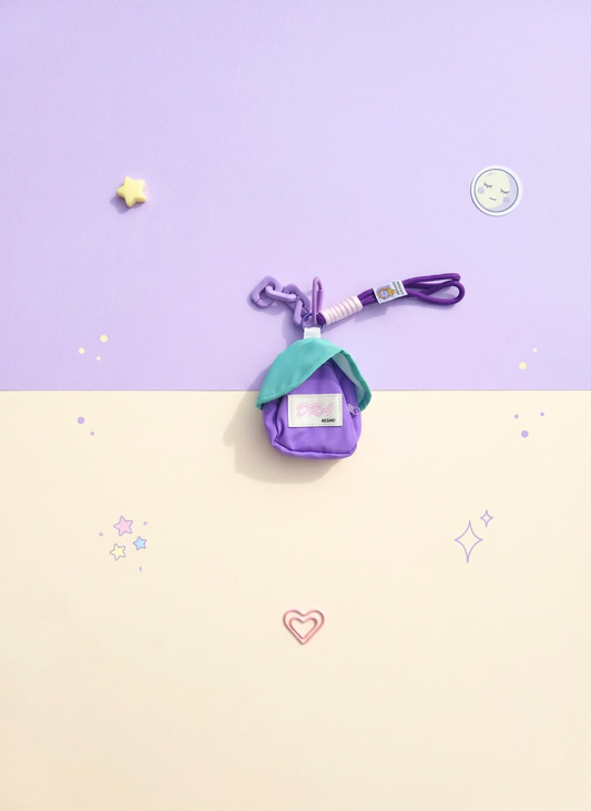 Small purple bag with a green top on a two-tone background with stars and hearts.
