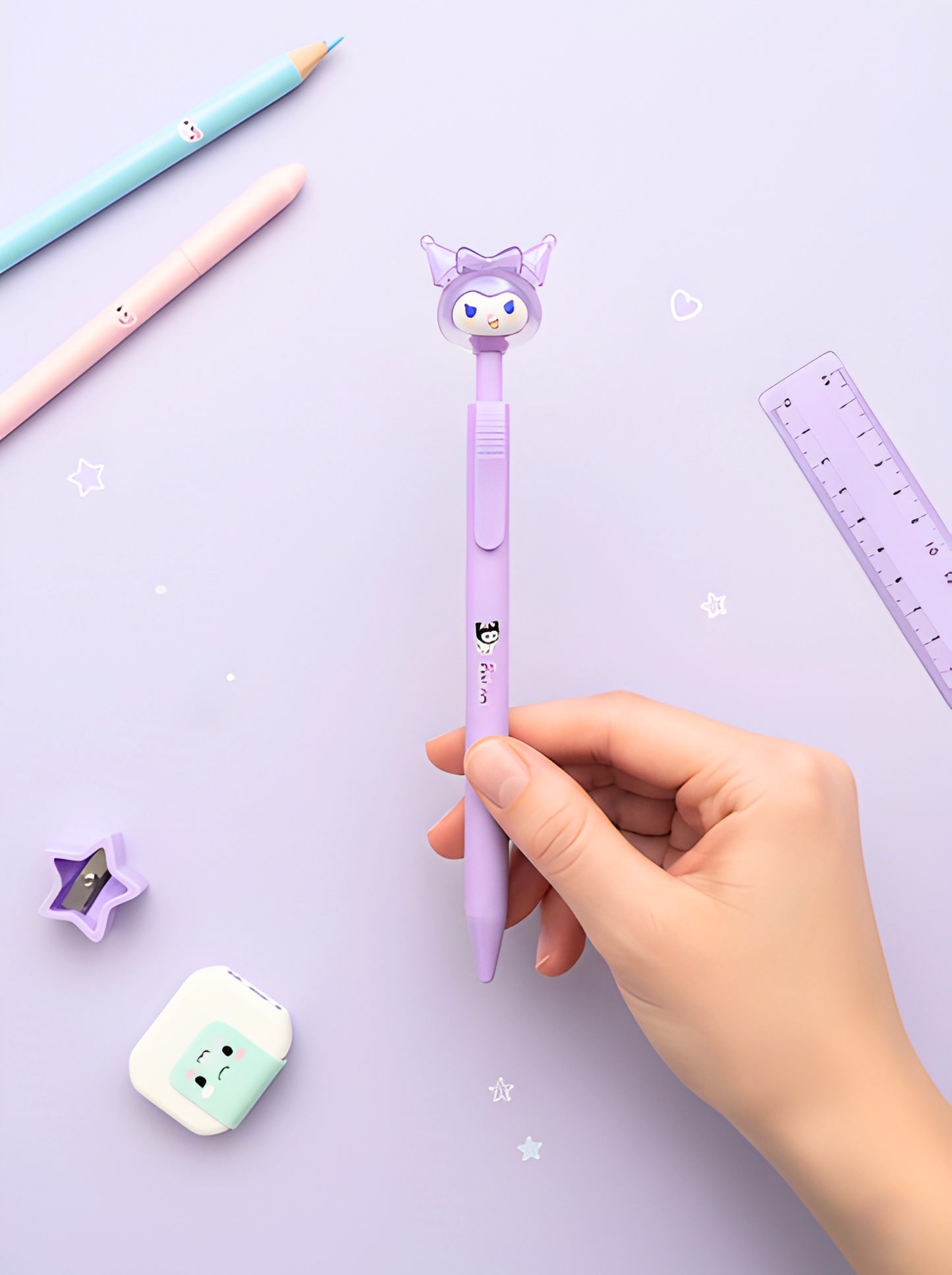 Hand holding a purple cartoon-themed pen on a light purple background with stationery items.