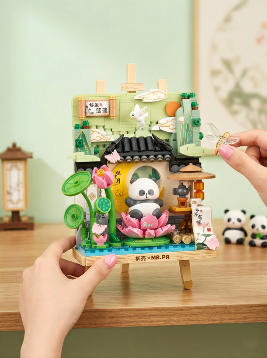 Small decorative model of a panda in a traditional Japanese setting on a wooden stand.