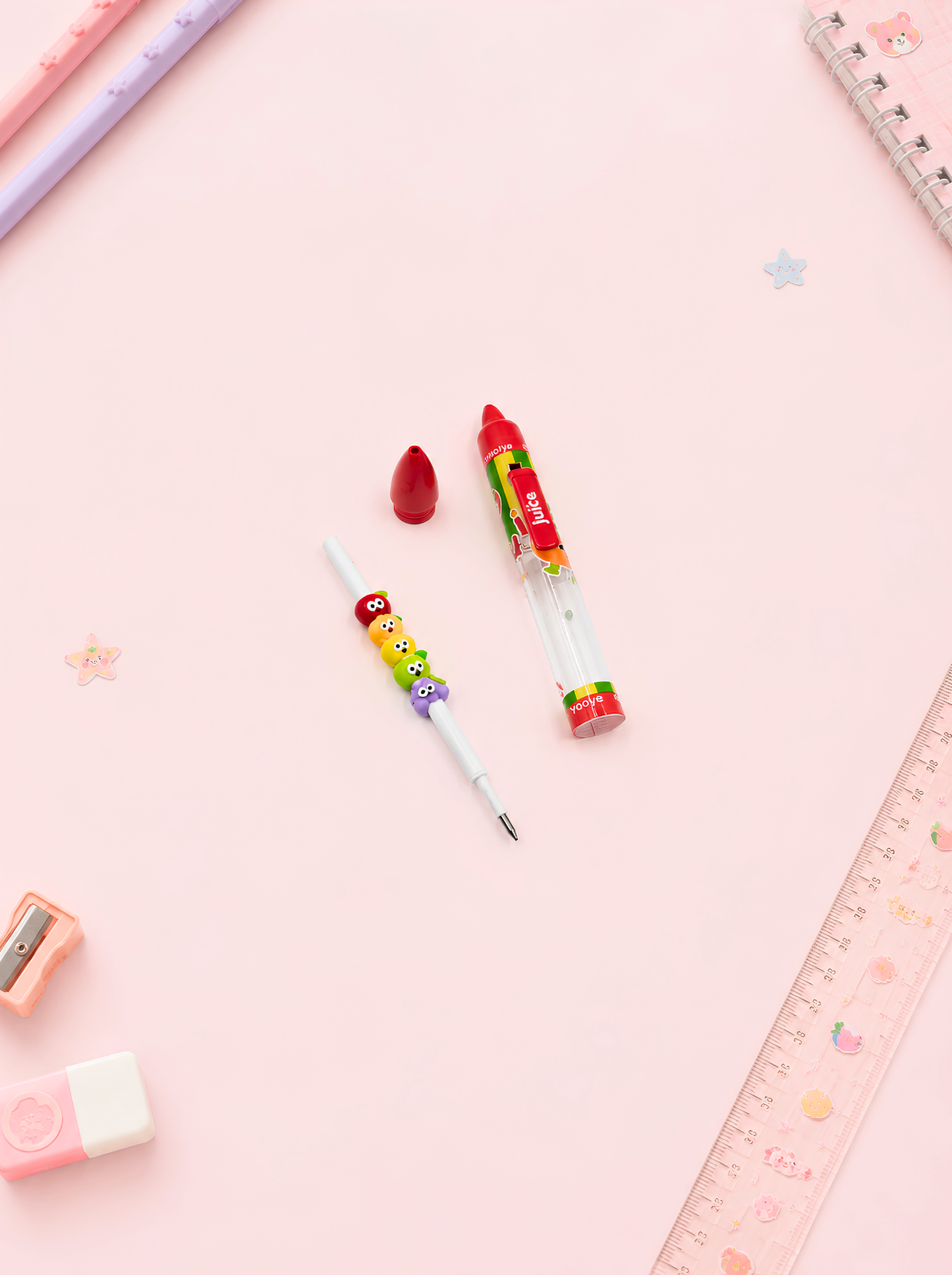 Colorful pens and stationery items on a pink background