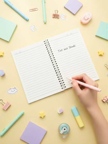 Open notebook with lined pages on a yellow background with stationery items