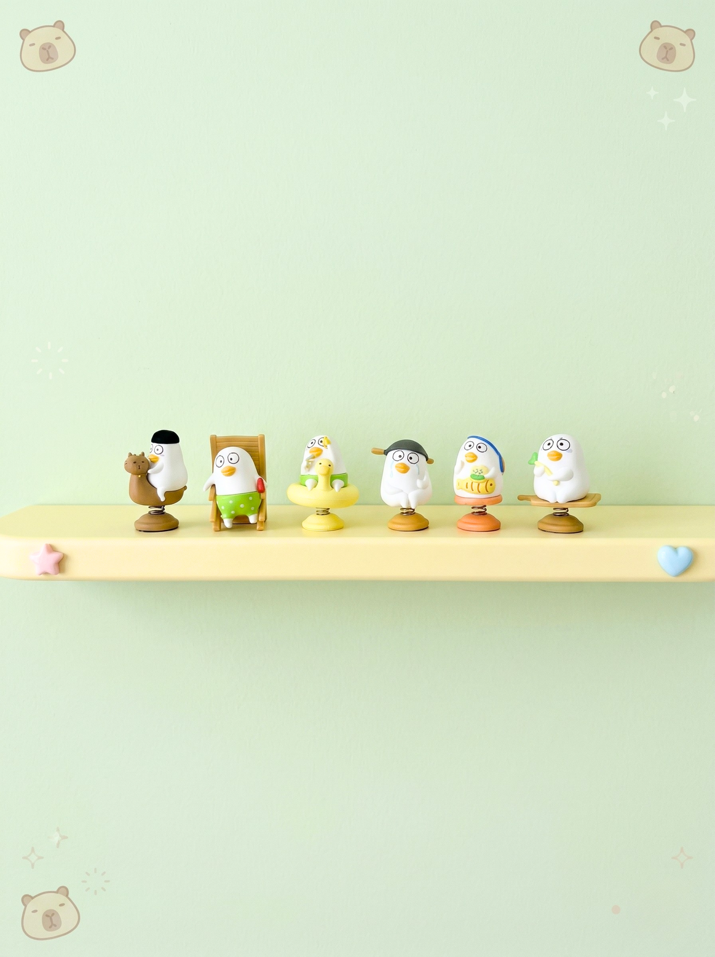 Set of small figurines on a shelf against a light green background