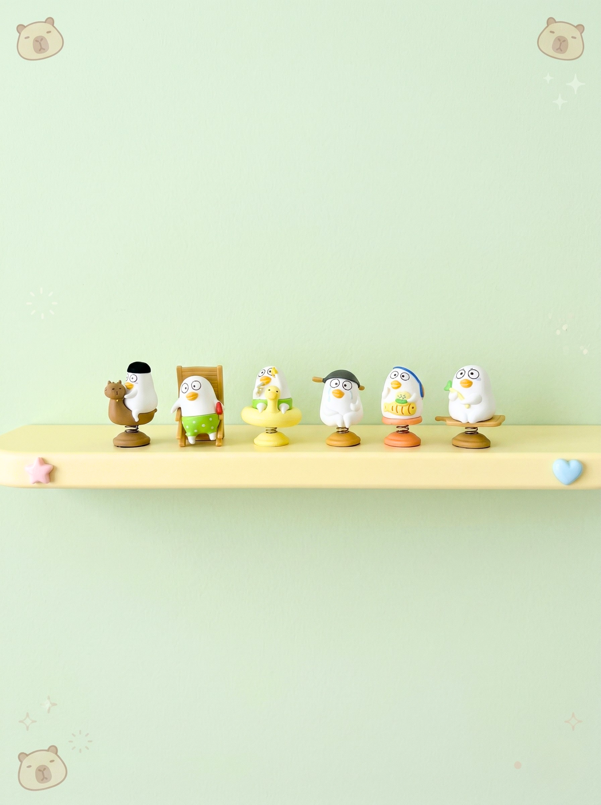 Set of small figurines on a shelf against a light green background