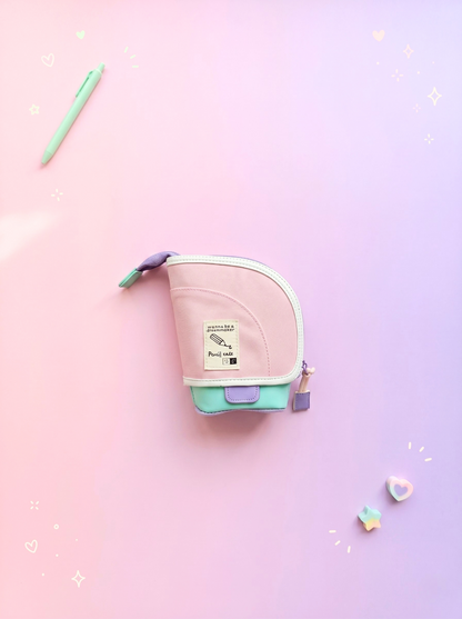 Small pink and green pouch on a gradient pink and purple background