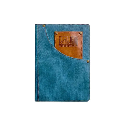 Blue denim notebook with brown leather patch and logo on a white background
