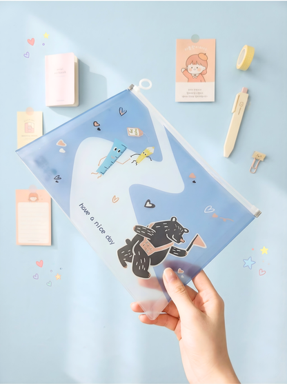 Clear plastic pouch with cartoon designs held by a hand on a light blue background