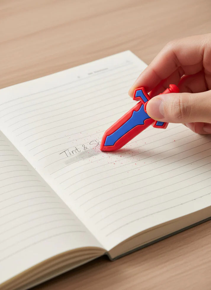 Hand holding a red and blue sword-shaped object over an open notebook
