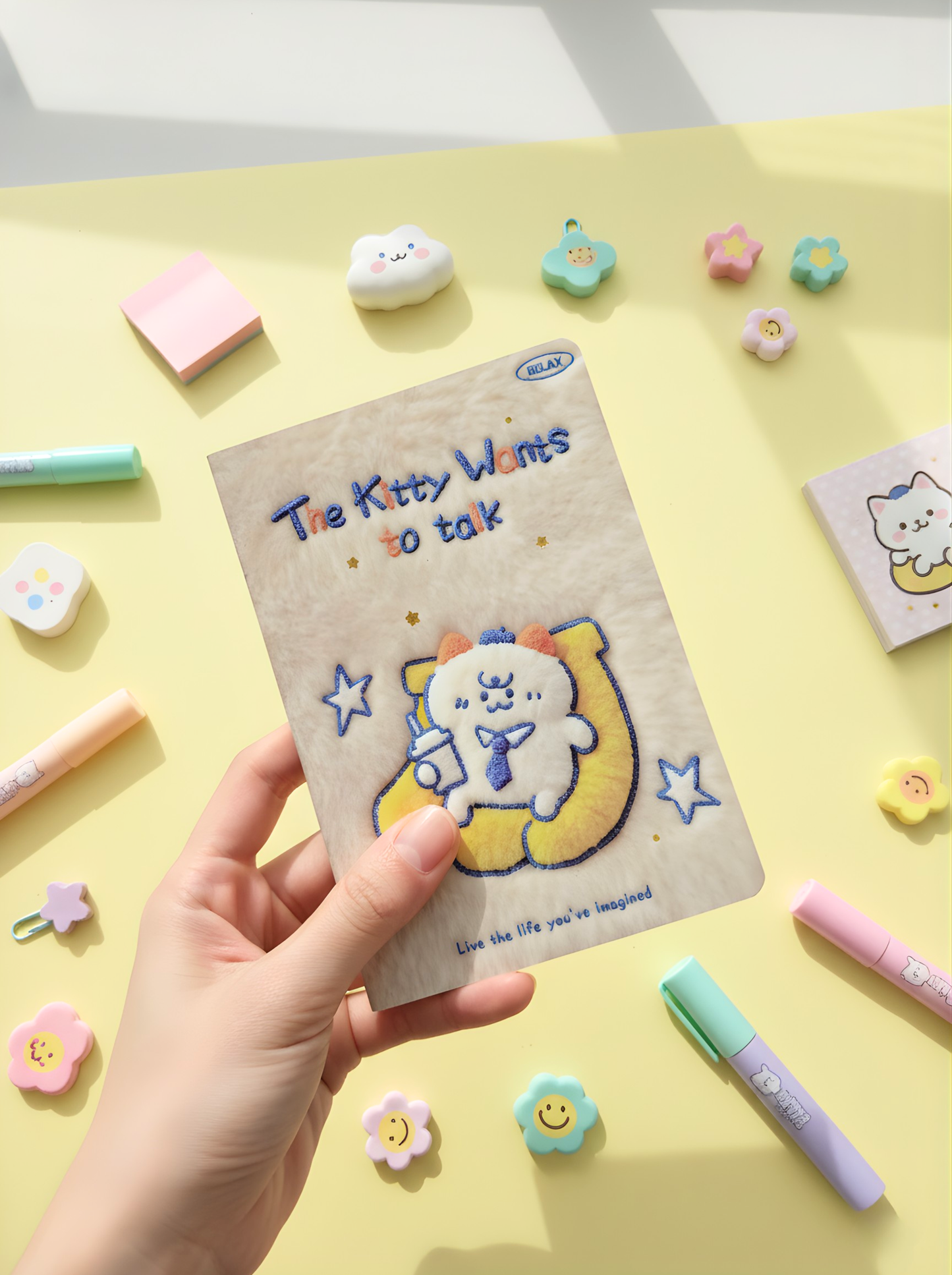 Notebook with cartoon characters held by a hand on a colorful stationery background