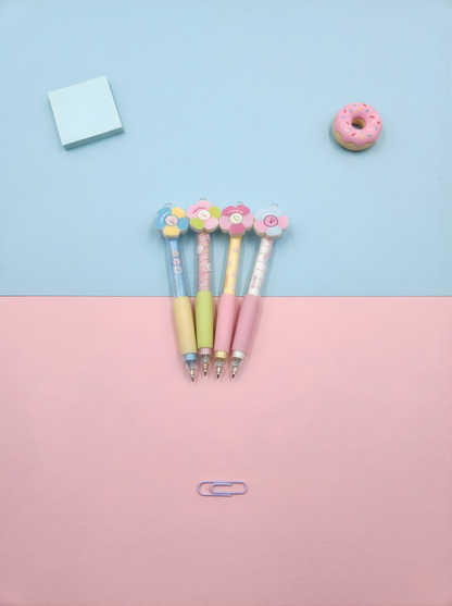Three colorful pens with floral designs on a pink and blue gradient background.