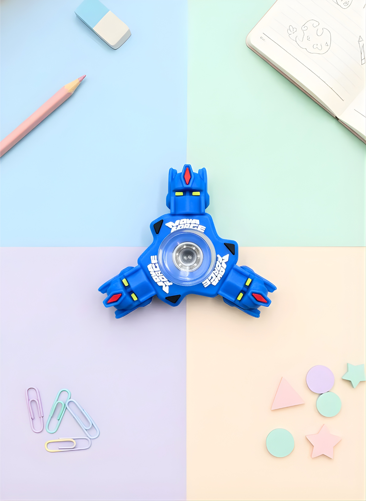 Blue toy with circular design on a colorful background with stationery items