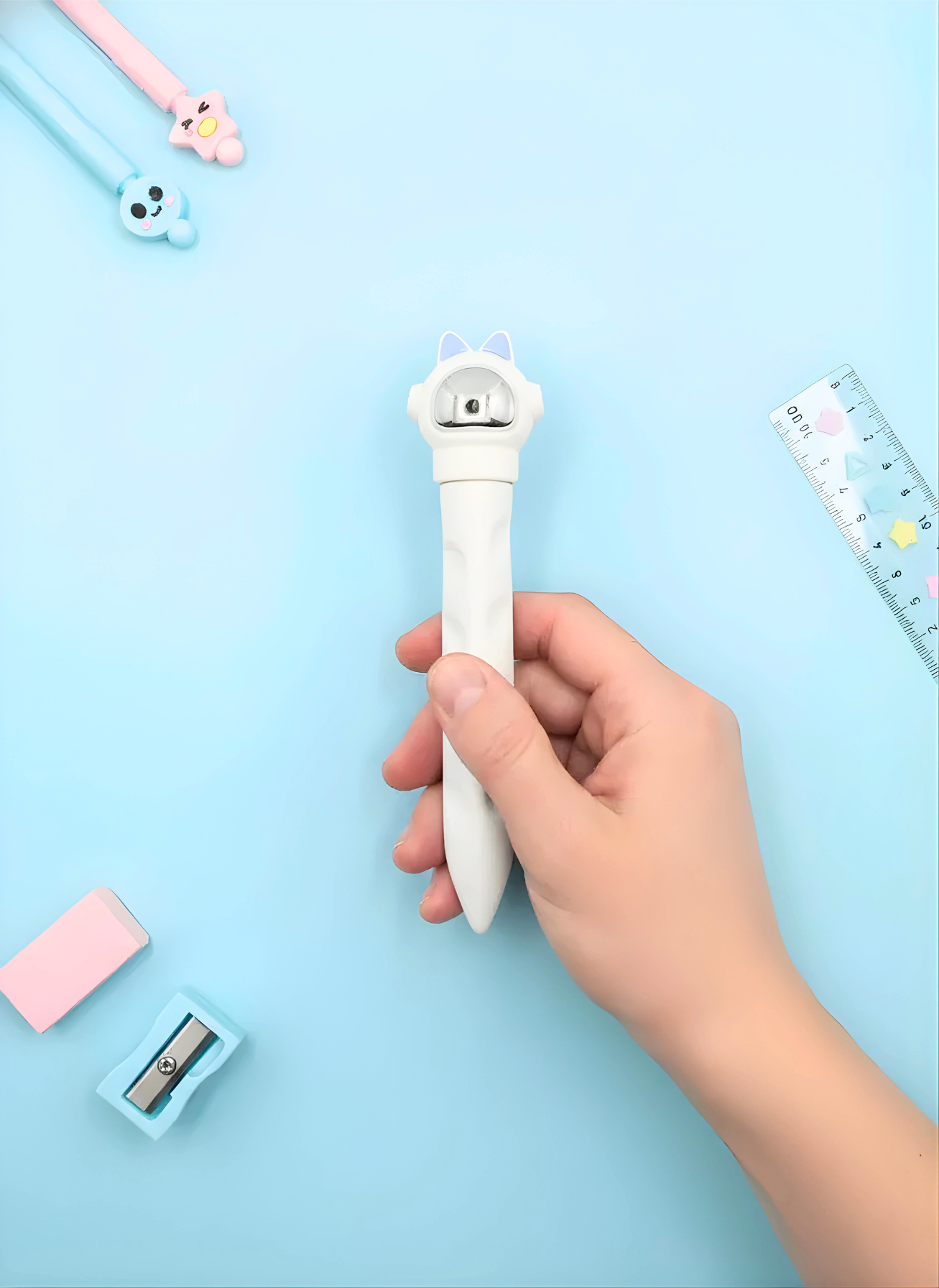Hand holding a white pen with a cartoon character on a light blue background