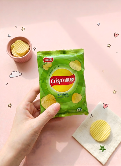 Hand holding a green packet of Crisps brand chips on a pink background