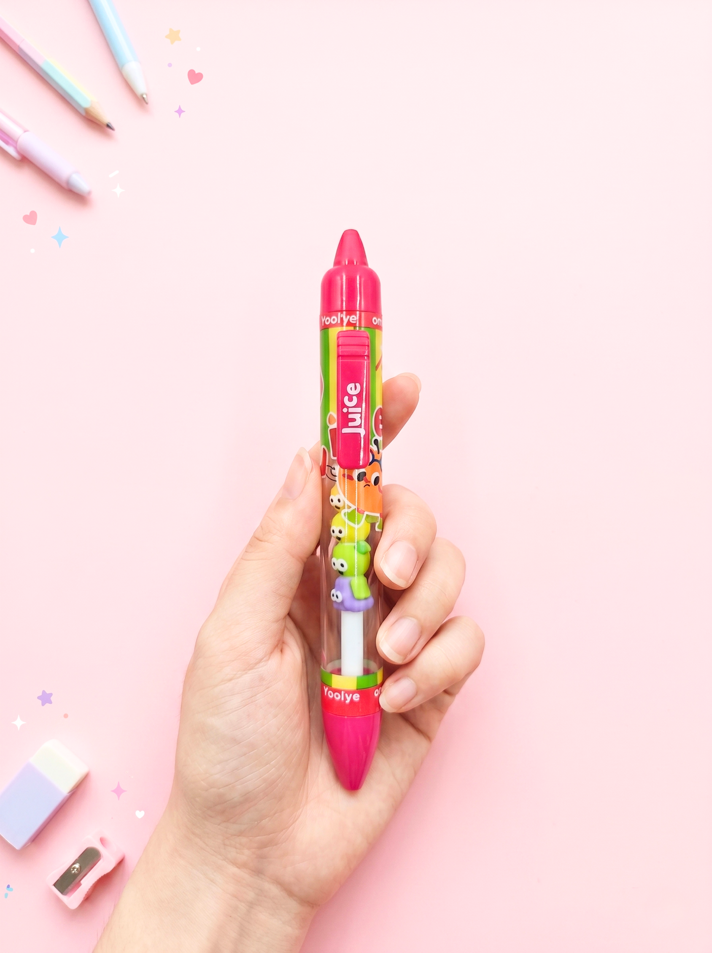 Hand holding a colorful juice box with a pink lid against a pink background