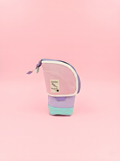 Small pink and purple bag with a visible brand label on a pink background