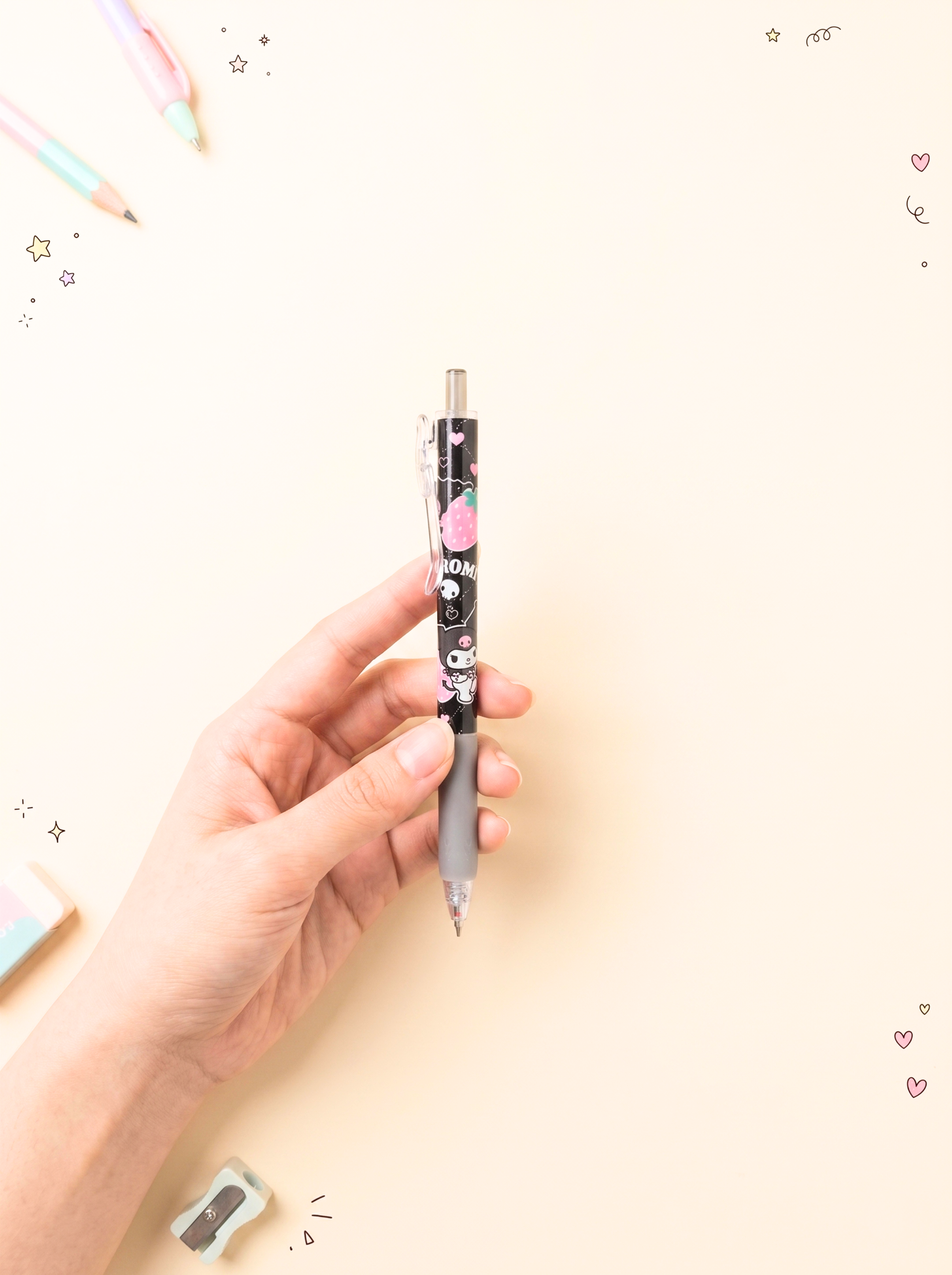 Hand holding a pen with a decorative design on a light background