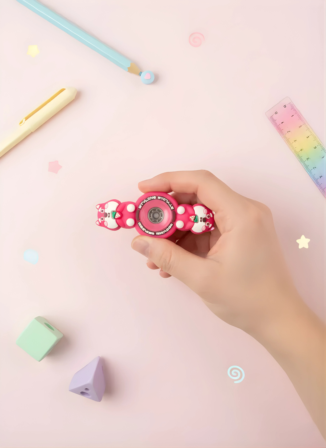 Hand holding a pink fidget spinner with colorful background