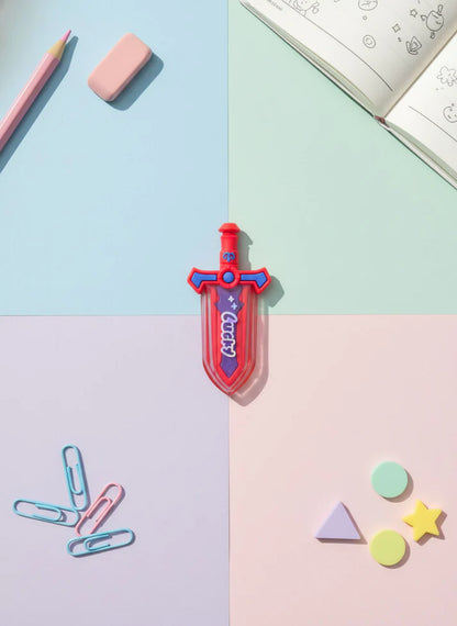 Colorful toy sword on a pastel grid background with stationery items.