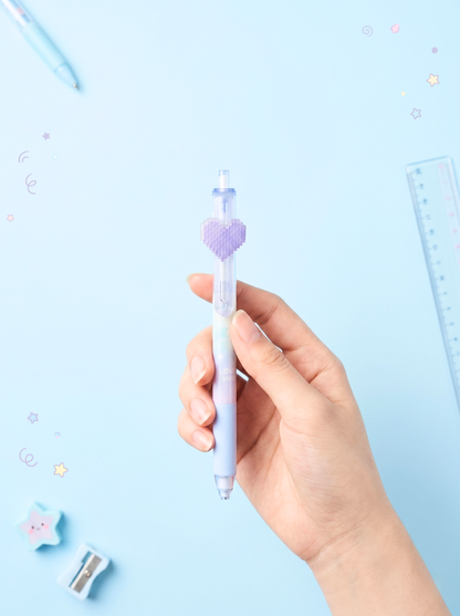 Hand holding a pen with a heart design on a light blue background
