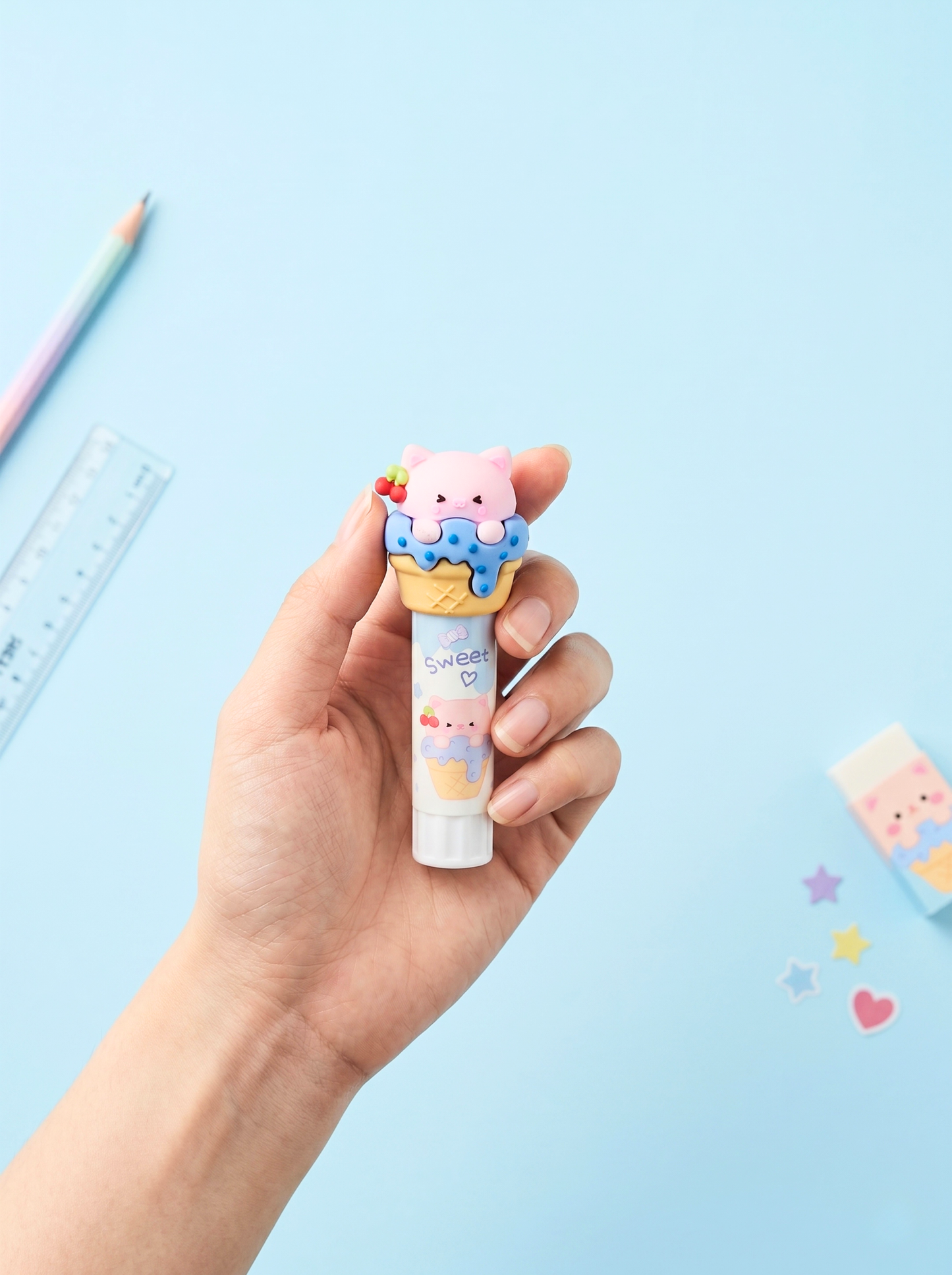 Hand holding a cute cartoon-shaped pen against a light blue background