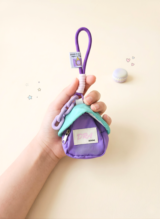 Purple and green pet toy with a tag held by a hand on a light background