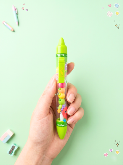Hand holding a colorful pen with a clear body against a light green background