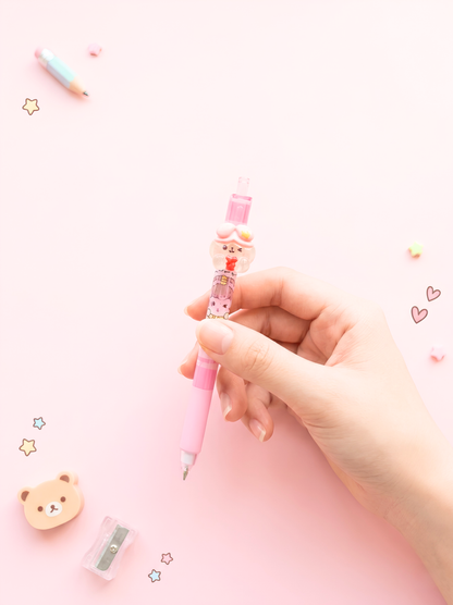 Hand holding a pink cartoon-themed pen with a small bear design on a light pink background.