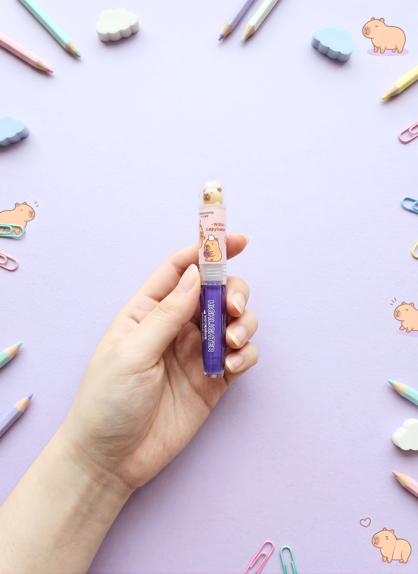 Hand holding a small bottle with a colorful background featuring stationery items.