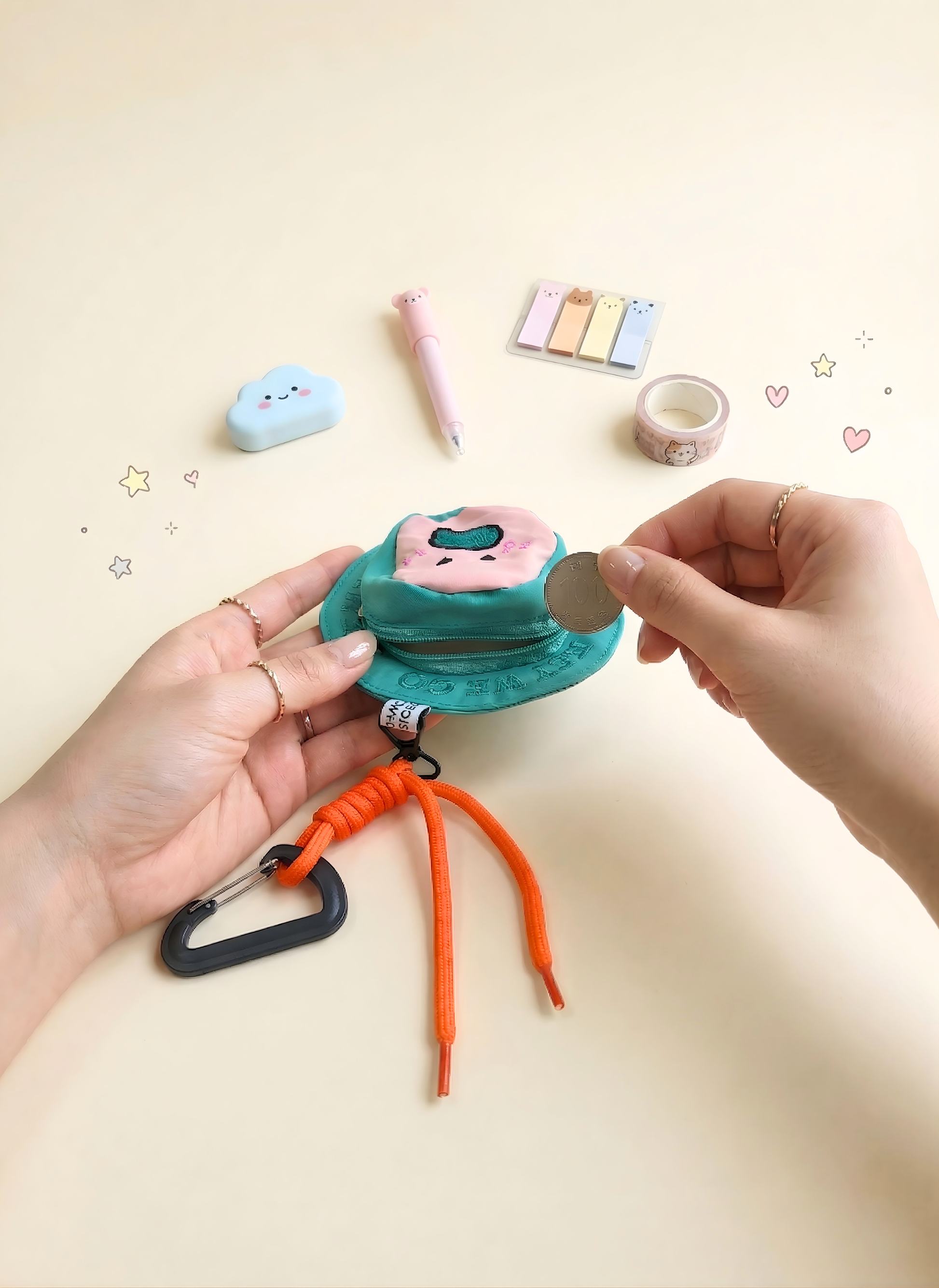 Person holding a small blue pouch with a pink pig design on a beige background.