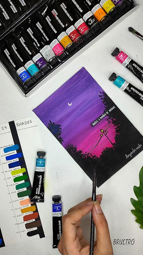 Art supplies including watercolor paints and a completed painting of a night sky with a crescent moon and silhouette.