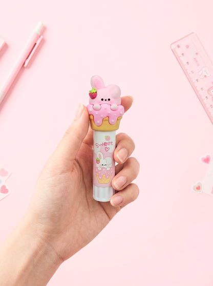 Hand holding a cute, cartoonish pink lip balm with a pink background