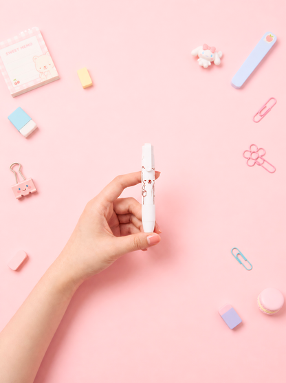 Hand holding a white pen with decorative elements on a pink background