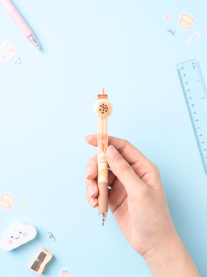 Hand holding a small pen with a decorative top on a light blue background