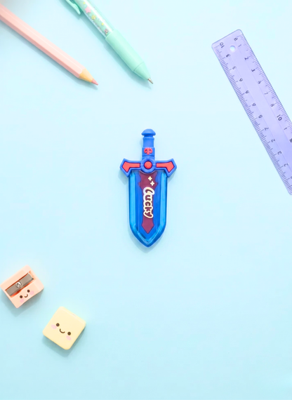 Colorful sword-shaped eraser on a light blue background with stationery items.