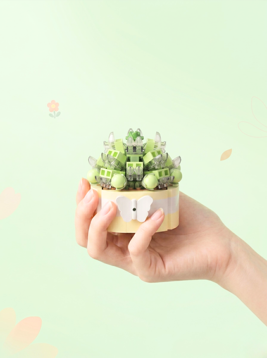 Hand holding a small green decorative item against a light green background