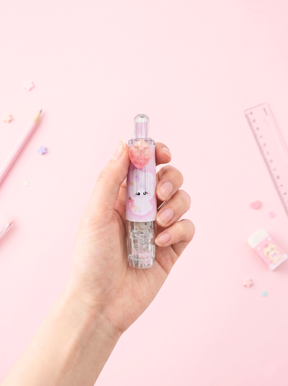 Hand holding a small bottle with a cute design on a pink background