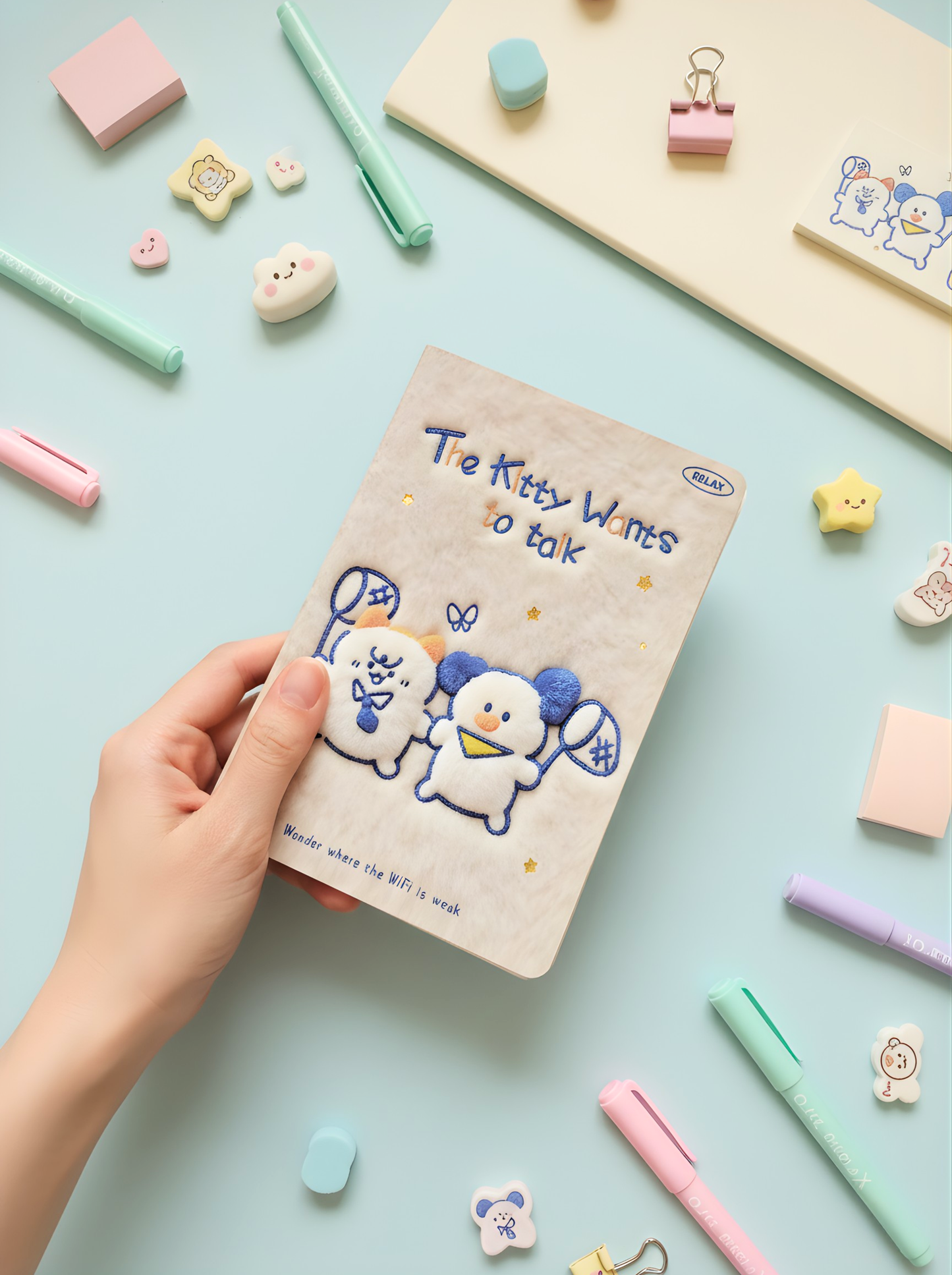 Notebook with cartoon characters held by a hand on a colorful stationery background