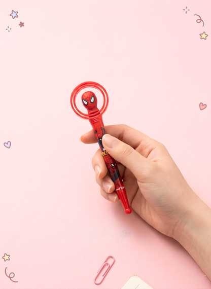Hand holding a red superhero-themed pen against a pink background