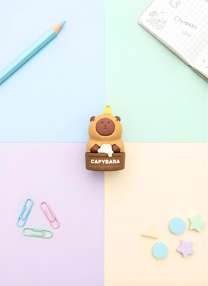 Capybara-shaped eraser on a colorful background with stationery items