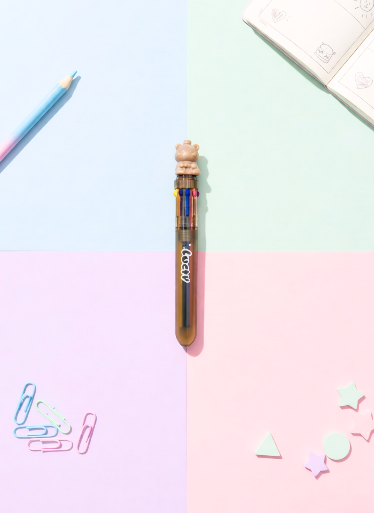 Multicolored pen with a bear-shaped top on a pastel background