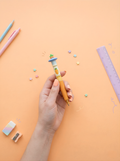 Hand holding a colorful pen with stationery items on a peach background