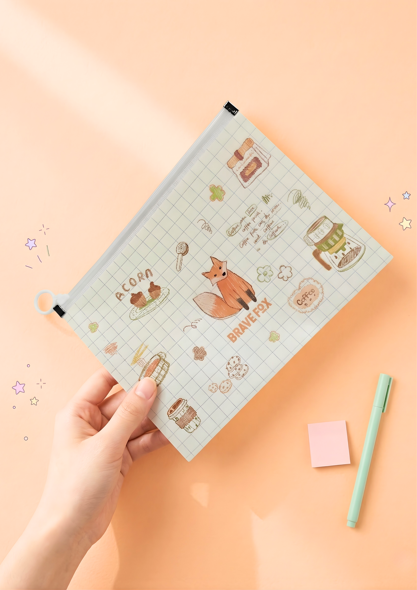 Planner with cute illustrations held by a hand on a peach background