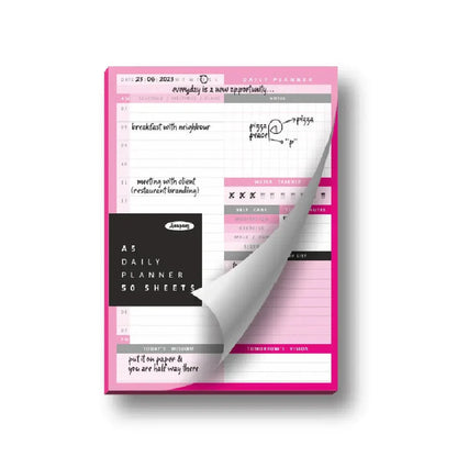 Pink daily planner with a clear flap showing the inside pages on a white background