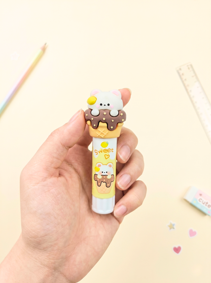 Hand holding a cute cartoon-style ice cream cone-shaped pen with a small character on a light background.
